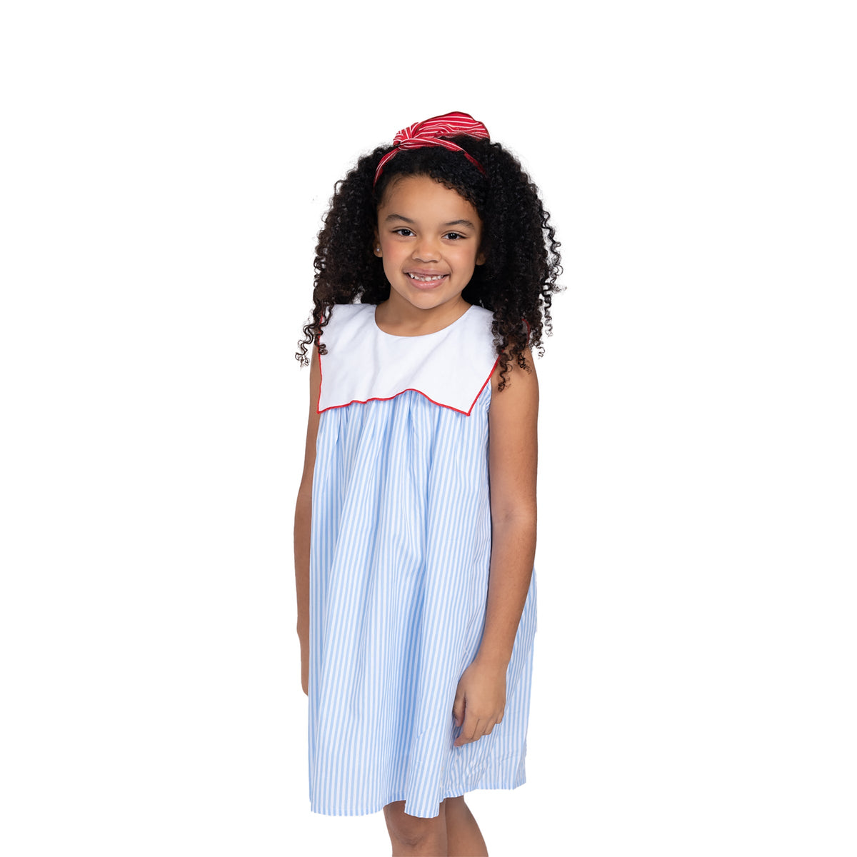 Close-up of Puvu Pior® blue striped dress, highlighting the white sailor collar, red piping, and red headband styling.