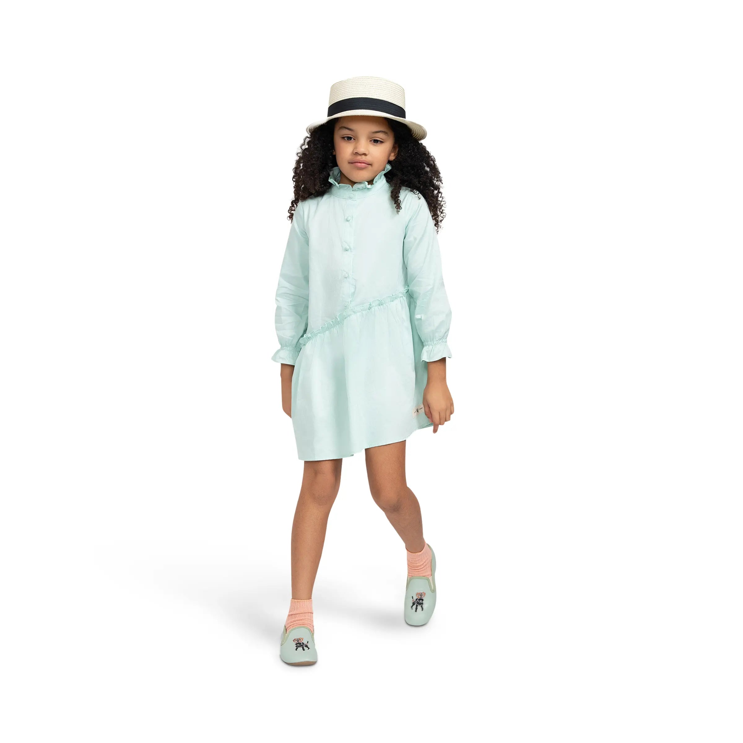 Model in Puvu Pior® mint green dress, stepping forward, to showcase the ease of movement and mock neck detail.