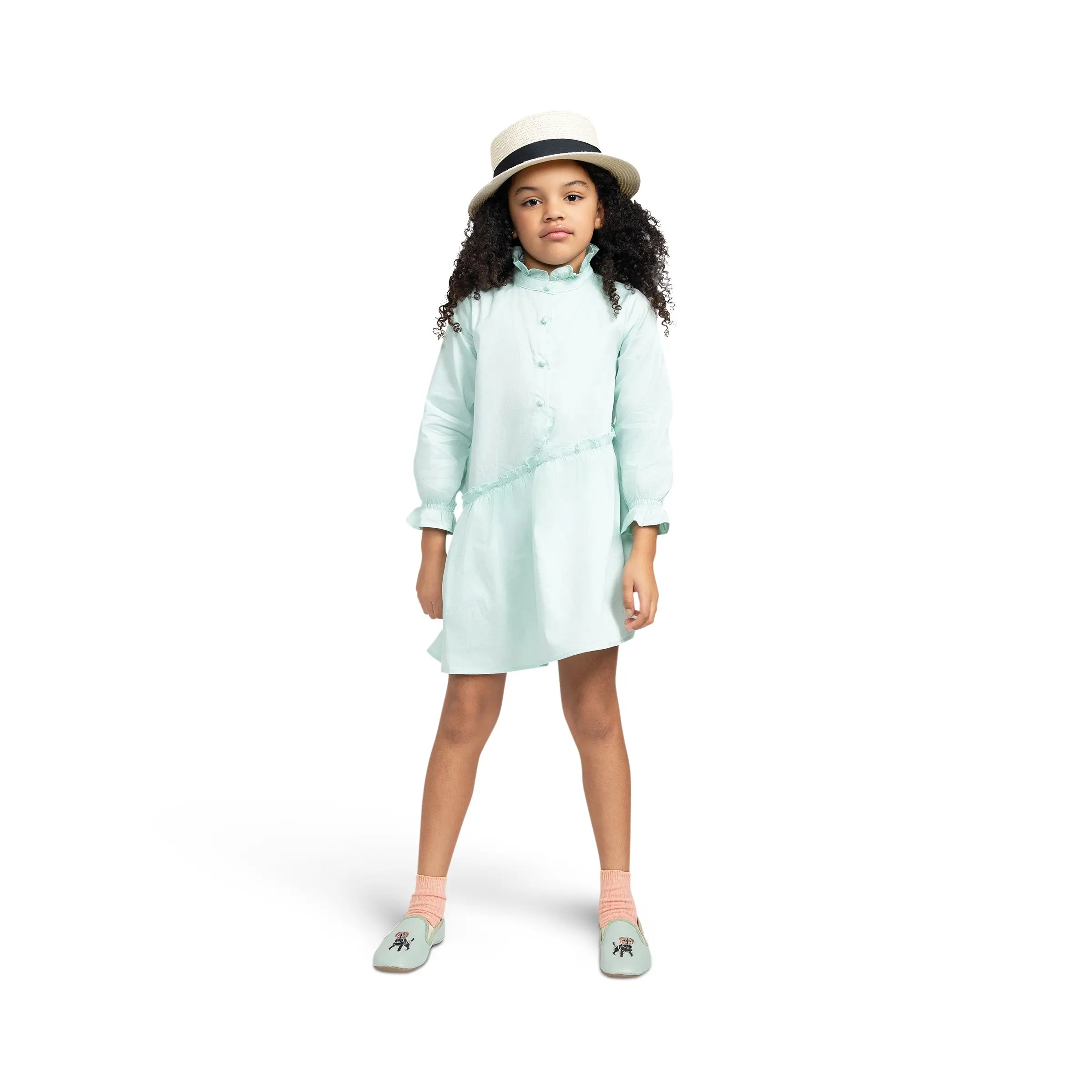 Girl modeling Puvu Pior® mint green poplin dress and straw hat, highlighting the elegant, sophisticated fit.