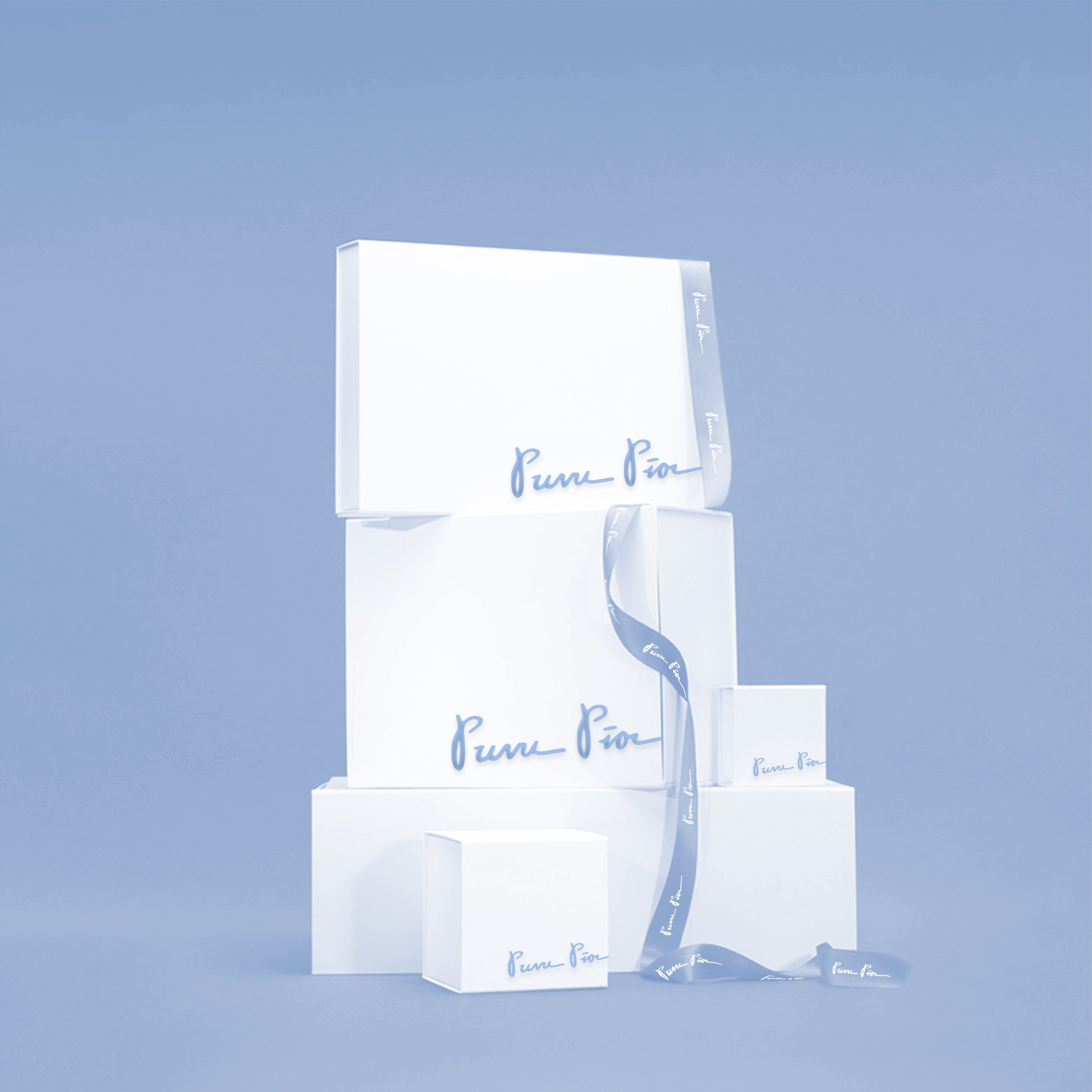 Puvu Pior® luxury gift packaging featuring stacked white boxes with blue script logo and matching brand-name satin ribbon.