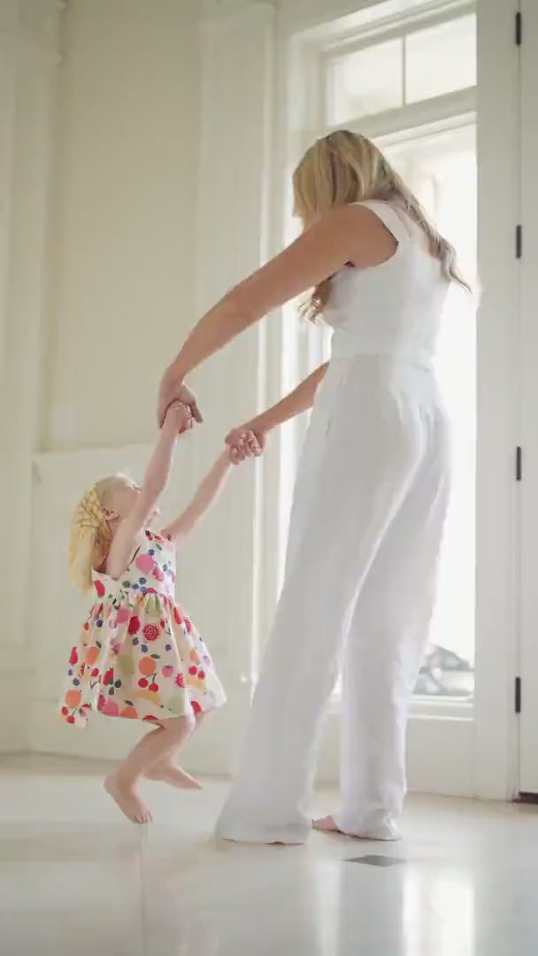 A cinematic Puvu Pior® campaign reel set in a luxury estate, featuring a young girl with her mother celebrating family connections. The video showcases the SS2026 collection, including botanical fruit-print dresses, highlighting the WOVENBOND™ philosophy through gentle embraces, and holding hands.